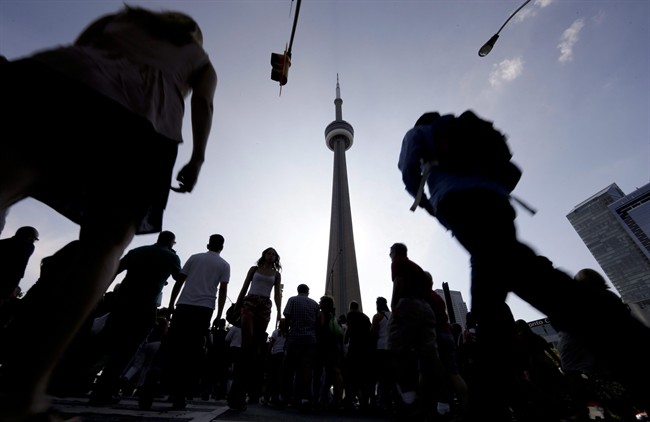 People make their way towards the CN Tower in downtown Toronto on .