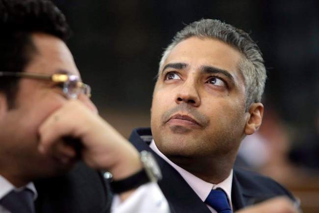 Mohamed Fahmy listens to his lawyer, Khaled Abou Bakr, during his retrial in a courtroom, of Tora prison, in Cairo, Egypt, Monday, June 1, 2015. 