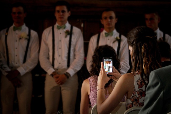 A guest is seen capturing an image on her cellphone at a wedding photographed by Lainie Hird Photography in May 2015.