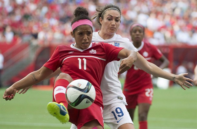 Canada's Desiree Scott fights for the ball with England's Jodie Taylor during second half of FIFA World Cup quarter-final soccer action in Vancouver, B.C. Saturday, June, 27, 2015. 