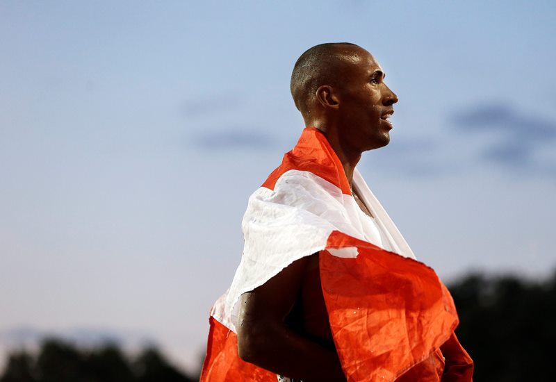 Decathlon champion Damian Warner of Canada wears a national flag following his win in the men's decathlon 1500 meter run at the Pan Am Games Thursday, July 23, 2015, in Toronto. 