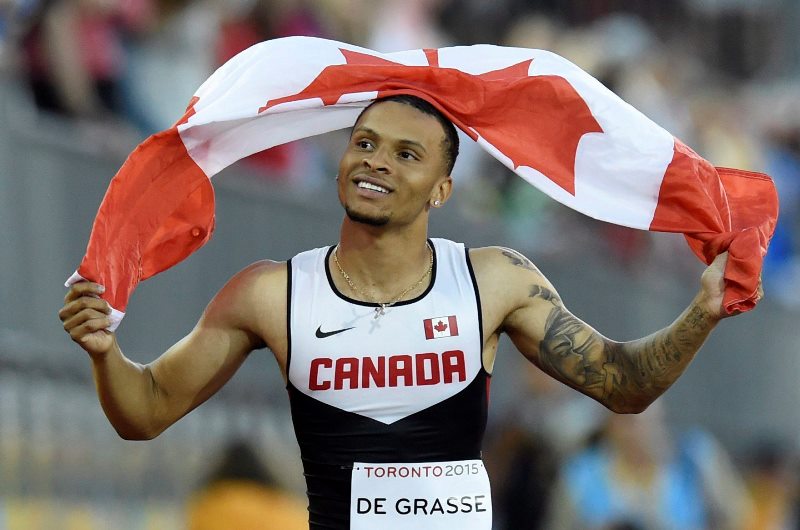 Andre De Grasse, of Canada, hold a flag after he wins the gold medal in the men's 100m final during the athletics competition at the 2015 Pan Am Games in Toronto on Wednesday, July 22, 2015. 