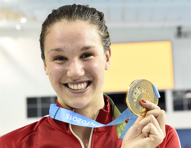 Chantal Van Landeghem, of Canada, smiles as she wears her gold medal after winning the women's 100m freestyle at the 2015 Pan Am Games in Toronto on Tuesday, July 14, 2015.