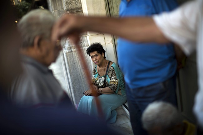 Pensioners wait for the opening of the national bank of Greece to withdraw a maximum of 120 euros for the week in central Athens, Thursday, July 16, 2015.