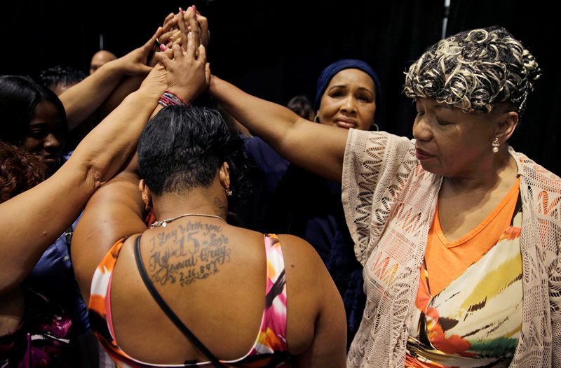 In this July 8, 2015 file photo, Gwen Carr, mother of Eric Garner, right, joins women whose families members were killed by police officers after New York Gov. Andrew Cuomo signed an executive order that puts the office of the state attorney general in charge of investigating killings by police. 
