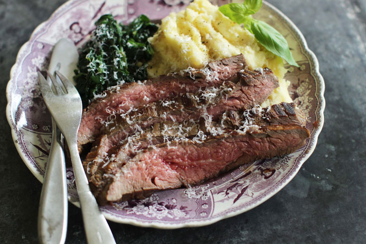 This June 15, 2015 photo shows marinated flank steak with seared spinach in Concord, N.H. This dish is from a recipe by Alison Ladman.