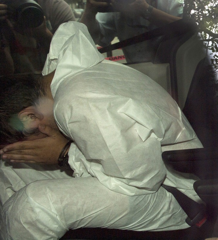 Nicholas Fontanelli hides from photographers as he arrives at the courthouse to be charged with first-degree murder of his fiancee, Samantha Higgins, Tuesday, July 14, 2015 in Montreal.