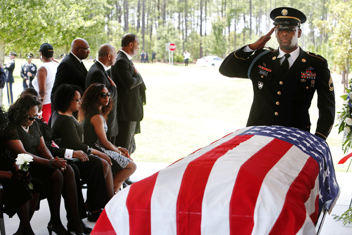 Corey Reeves, a member of the Fort Jackson Honor Platoon, helps perform a burial service for Rev. Daniel Simmons Sr. at Fort Jackson National Cemetery in Columbia, S.C., Thursday, July 2, 2015.