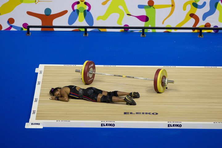 Venezuela's Genesis Rodriguez Gomez collapses during a lift attempt in the women's 53kg weightlifting at the Pan Am Games in Oshawa, Ontario, Sunday, July 12, 2015. Rodriguez took silver in the event.