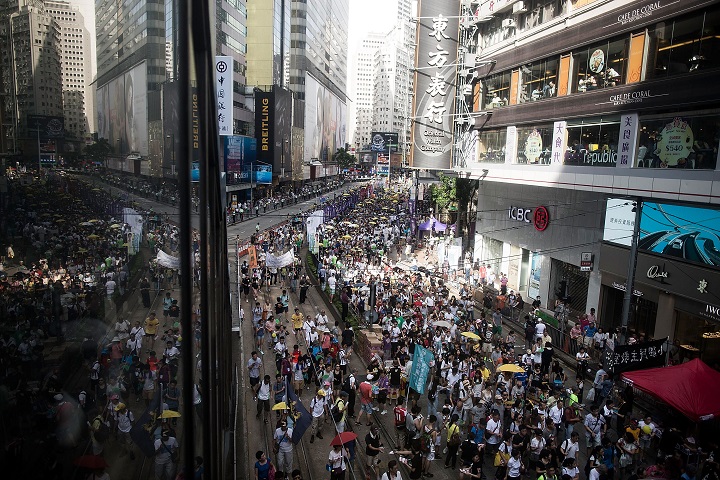 Protesters march on a street during a rally as they hold banners and shout slogans on July 1, 2015 in Hong Kong. July 1 is traditionally a day of protest in Hong Kong and also marks the anniversary of the handover from Britain to China in 1997, under a 'one country, two systems' agreement. (Photo by Anthony Kwan/Getty Images).