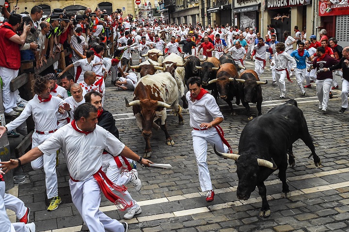 Revellers run with the Tajo and the Reina's fighting bulls entering Estafeta street during the third day of the San Fermin Running of the Bulls festival on July 8, 2015 in Pamplona, Spain.