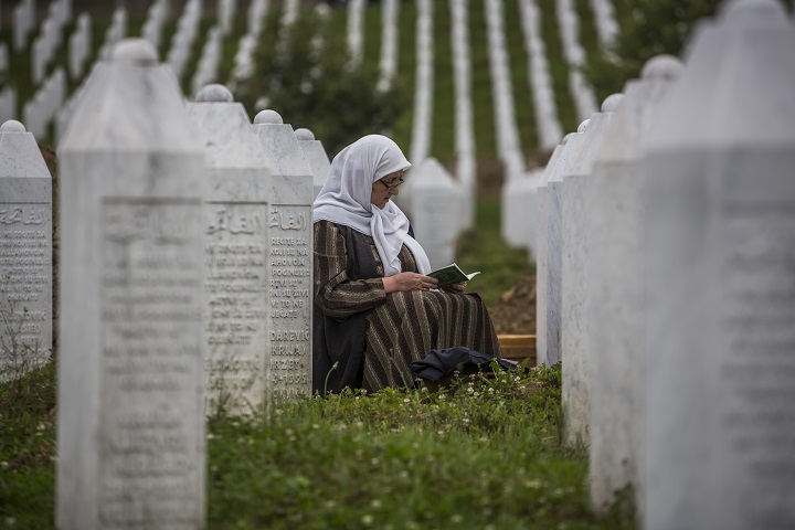  A woman prays at the Potocari cemetery and memorial near Srebrenica on July 9, 2015 in Srebrenica, Bosnia and Herzegovina. The newly-identified remains of another 136 victims from Srebrenica massacre will be buried at a ceremony on July 11, 2015 on the 20th anniversary of the massacre. At least 8,300 Bosnian Muslim men and boys who had sought safe heaven at the U.N.-protected enclave at Srebrenica were killed by members of the Republic of Serbia (Republika Srpska) army under the leadership of General Ratko Mladic, who is currently facing charges of war crimes at The Hague, during the Bosnian war in 1995.  (Photo by Matej Divizna/Getty Images).