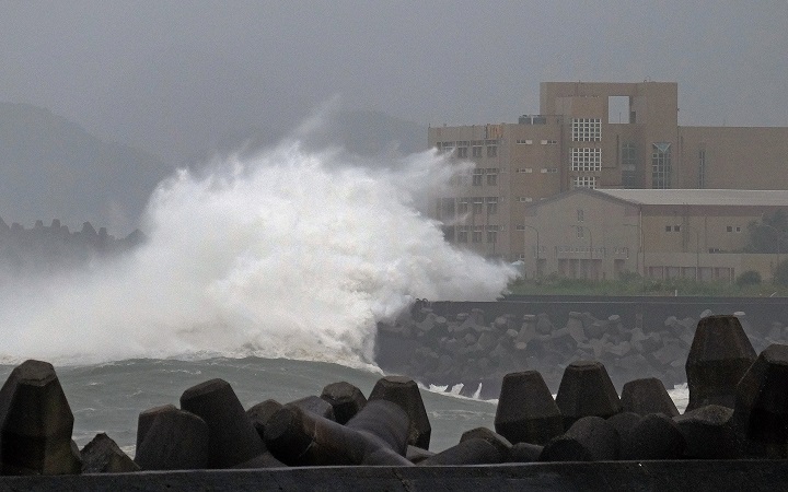 Giant waves crash into the coastline next to National Taiwan Ocean University (R) in Keelung as Typhoon Chan-hom brings rain to northern Taiwan on July 10, 2015.  Taiwan was bracing for fierce winds and torrential rains on July 10 as Typhoon Chan-hom gained momentum and the island's stock market, schools and offices closed in preparation for the storm. 