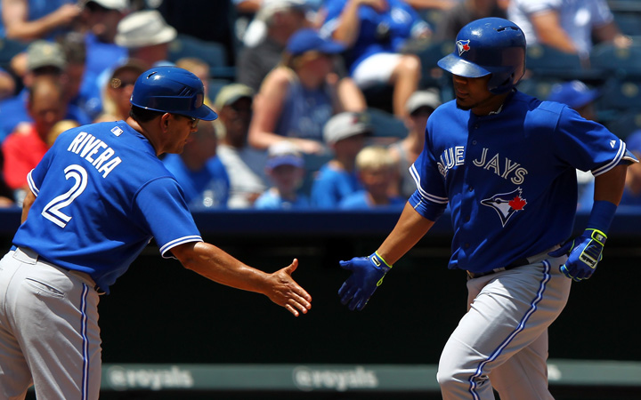 Edwin Encarnacion of the Toronto Blue Jays is congratulated by third base coach Luis Rivera of the Toronto Blue Jays after hitting a two-run home run in the 4th inning of the game against the Kansas City Royals at Kauffman Stadium on July 11, 2015 in Kansas City, Missouri. 