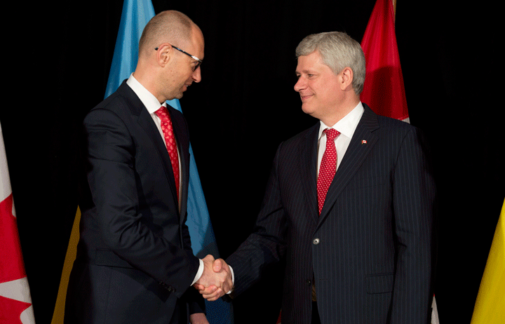 Canadian Prime Minister Stephen Harper, right, shakes hands with Ukrainian Prime Minister Arseniy Yatsenyuk after signing a trade agreement at Willson house in Chelsea, Que., Tuesday, July 14, 2015.