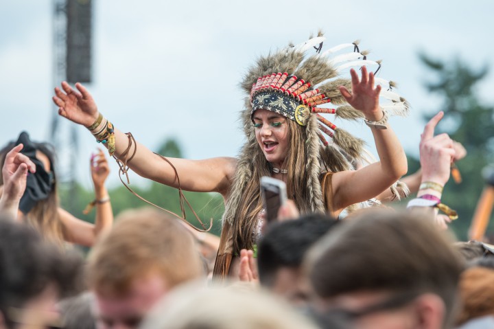 A festival go-er wears a headdress.
