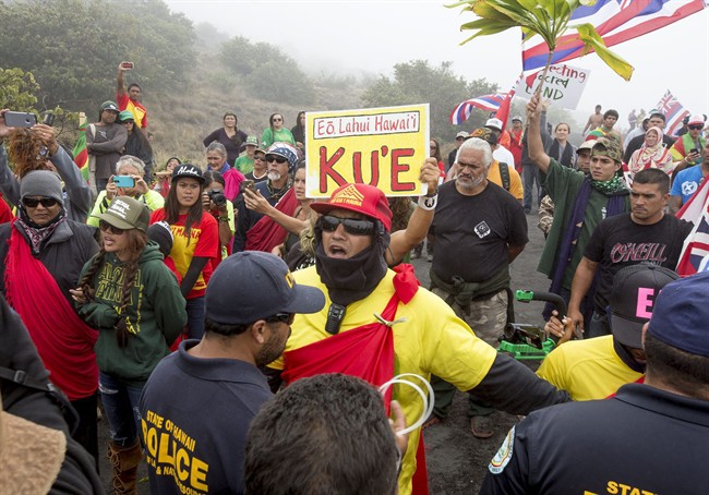 A Department of Land and Natural Resources official talks with Thirty Meter Telescope protesters at one of many blockades that started at the Mauna Kea visitor center, stopping construction vehicles from driving up to the summit of the mountain on June 24, 2015.