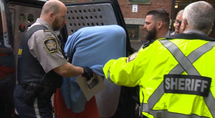 Jimmy Melvin Jr. covers his face as he is led into court on July 20, 2015.