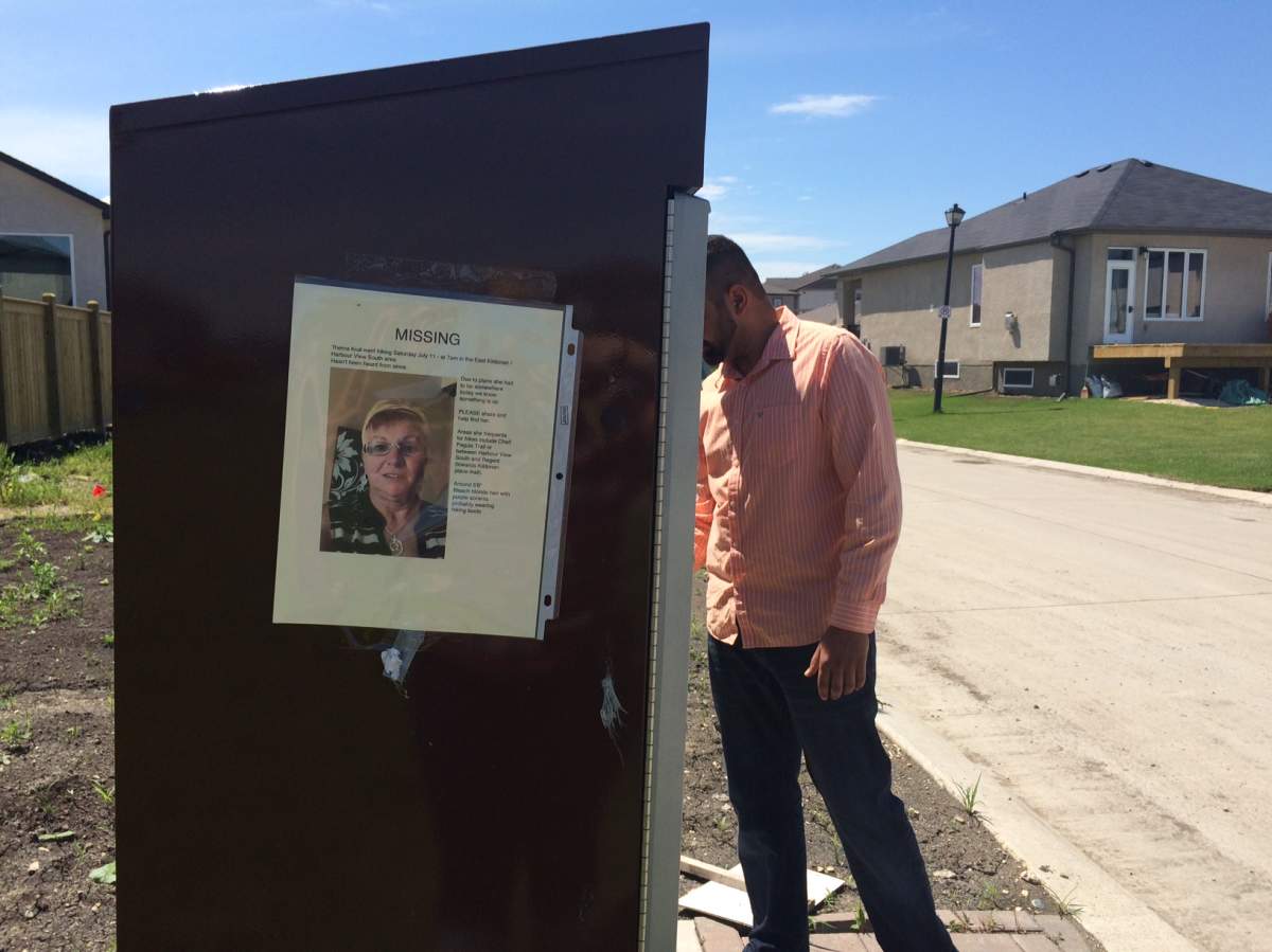Volunteers place posters on mailboxes in Harbourview South while searching for Thelma Krull.