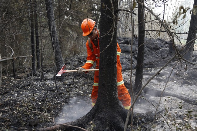 Cpl. Kevin Deng puts out a hot spot at the remote Saskatchewan community of Montreal Lake on Thursday, July 9, 2015. 