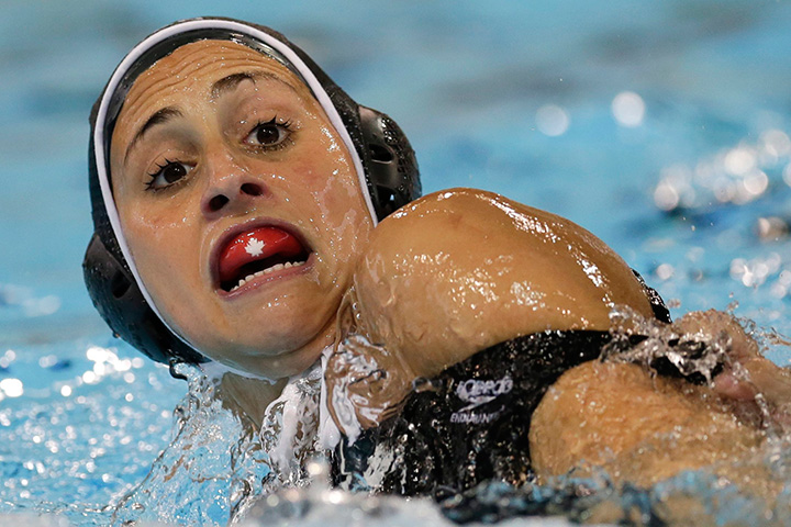 Canada's Joelle Bekhazi reacts as she is grabbed by Venezuela's Nibley Pina Tovar during a water polo match at the Pan Am Games in Markham, Ontario, Wednesday, July 8, 2015. 