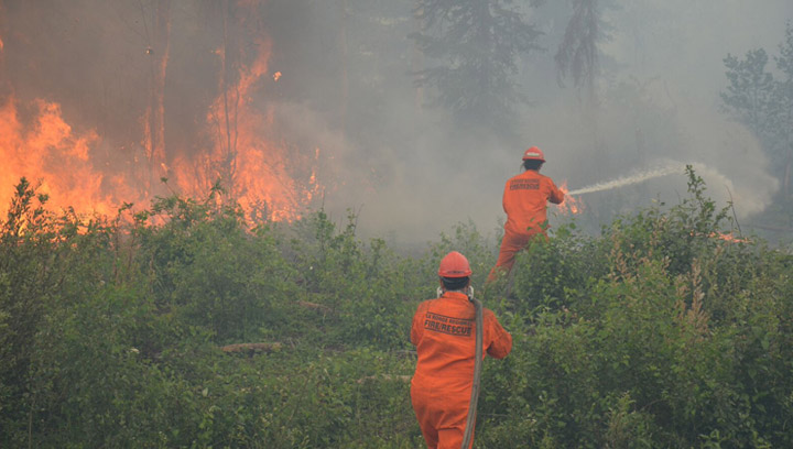 Crews battle a wildfire near La Ronge, Sask. on July 5, 2015. Soldiers started to receive training on Monday to help fight wildfires in northern Saskatchewan as flames inch closer to the community.