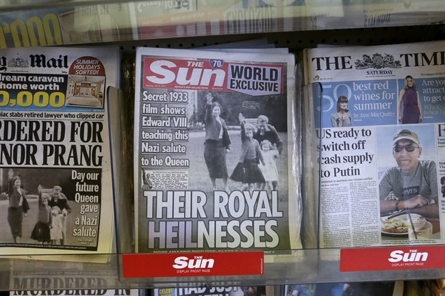 A row of newspapers on display including a paper with a photo of Britain's Queen Elizabeth as a child giving a Nazi salute, in a shop, in London, Saturday July 18, 2015.
