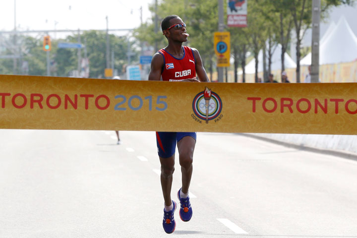 Cuba's Richer Perez gestures before crossing the finish line to win gold in the running of the men's marathon at the Pan Am Games, Saturday, July 25, 2015, in Toronto. 