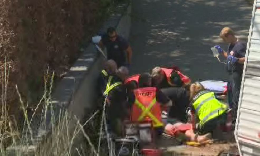 Emergency responders attend to injured motorcyclist.