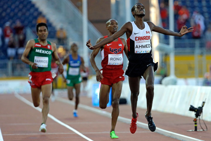 Canada's Mohammed Ahmed crosses the finish line during the finals of the men's 10,000 meter run at the Pan Am Games in Toronto, Tuesday, July 21, 2015. Ahmed won the gold medal.