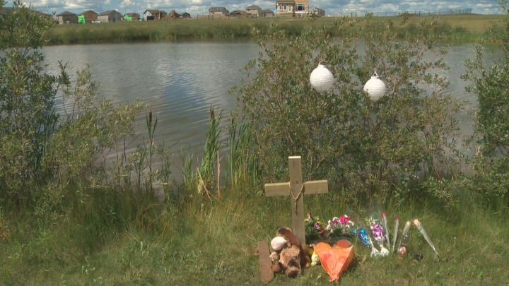 A memorial grows near a Morinville pond where a two-year-old drowned Saturday, July 25, 2015.