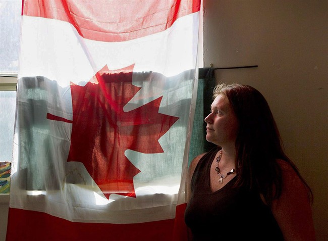 In this Aug. 30, 2012, file photo, war resister Kim Rivera, who fled the U.S. military in order to avoid the war in Iraq, poses for a photo in her Toronto home, before being deported back to the United States.