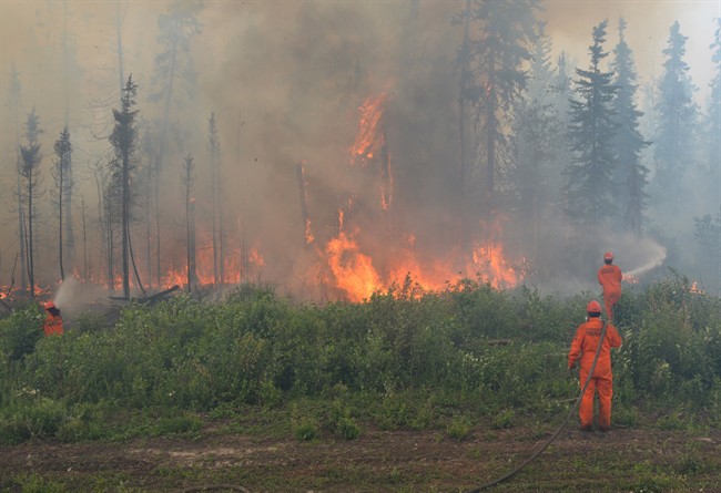 Firefighters battle a wildfire near La Ronge, Saskatchewan, Sunday, July 5, 2015.