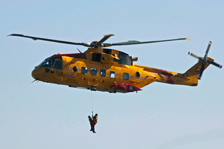 FILE: Search and rescue technicians are hoisted by a Cormorant helicopter during a Canada-United States coast guard ceremony in Halifax.