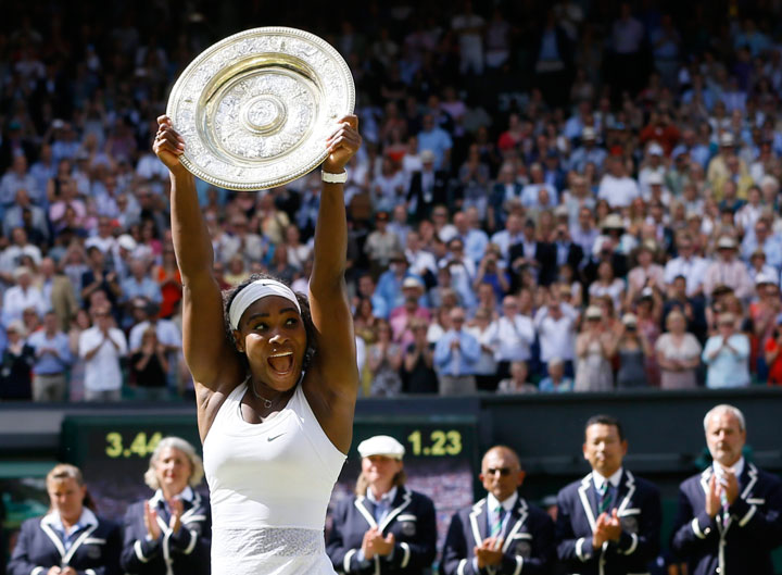 Serena Williams of the United States holds up the trophy after winning the women's singles final against Garbine Muguruza of Spain, at the All England Lawn Tennis Championships in Wimbledon, London, Saturday July 11, 2015. 