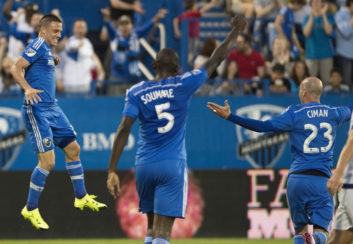 Montreal Impact's Donny Toia, left, celebrates with teammates Bakary Soumare (5) and Laurent Ciman (23) after scoring against Orlando City SC during first half MLS soccer action in Montreal, Saturday, June 20, 2015.
