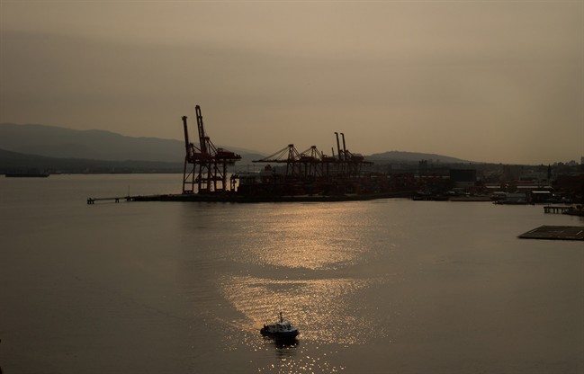 A port authority boat prepares to dock as smoke from wildfires shrouds the harbour in Vancouver, B.C., on Tuesday July 7, 2015. A thick haze has hung over British Columbia's south coast since Sunday as winds push smoke south from the many forest fires burning across the province. 