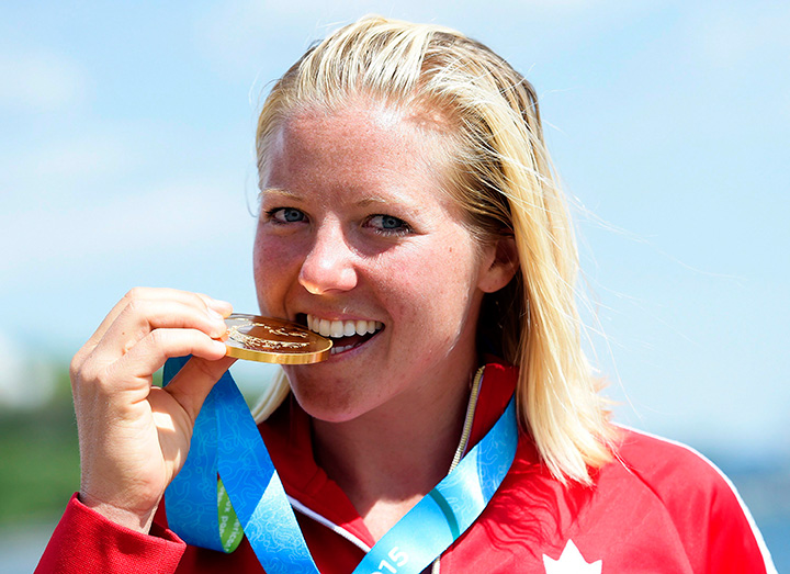 Canada’s Whitney McClintock bites her gold medal after winning the women’s water skiing overall gold medal final at the Pan Am Games in Toronto on Wednesday, July 22, 2015.