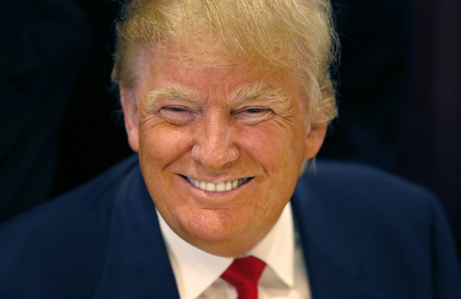 In this June 29, 2015, file photo, Republican presidential candidate Donald Trump smiles for a photographer before he addresses members of the City Club of Chicago, in Chicago.