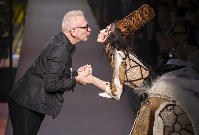 French designer Jean Paul Gaultier and a model wearing one of his creation are about to kiss during the presentation of his fall-winter 2015/2016 Haute Couture fashion collection, in Paris, France, Wednesday, July 8, 2015.