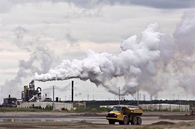 FILE -- A dump truck works near the Syncrude oil sands extraction facility near the town of Fort McMurray, Alberta on Sunday June 1, 2014.