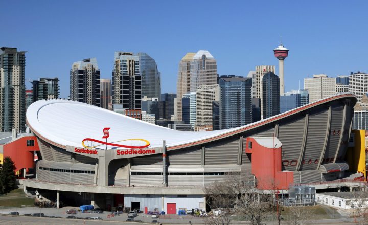 The Saddledome arena, home to the Calgary Flames, in the foreground of the downtown skyline in Calgary, Alberta on March 31, 2015.  