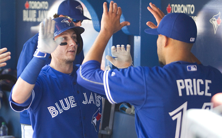 Toronto Blue Jays starting pitcher David Price, right, greets teammate Troy Tulowitzki in the dugout after he scored in the seventh inning of their AL baseball game against the Minnesota Twins, in Toronto on Monday August 3, 2015. 