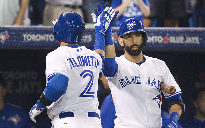 Toronto Blue Jays' Troy Tulowitzky, left, gets a high five from teammate Jose Bautista after he hit a solo home run against the Minnesota Twins during third inning AL baseball action in Toronto on Monday, August 4, 2015.
