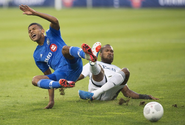 Montreal Impact's Johan Venegas, left, is tackled by Vancouver Whitecaps' Kendall Waston during first half Amway Canadian Championship final first leg soccer action in Montreal, Wednesday, August 12, 2015.