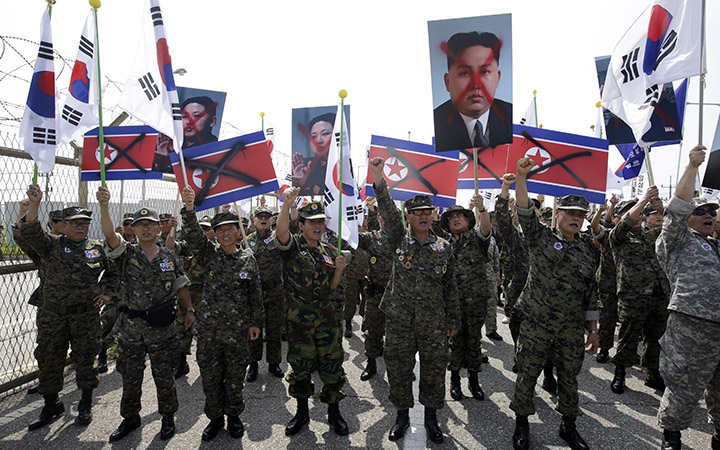 Members of the Korean Disabled Veterans Association by Agent Orange in Vietnam War, shout slogans as they hold mock North Korean flags and defaced images of North Korean leader Kim Jong Un during a rally denouncing the North Korea in front of the Unification Bridge near the border village of Panmunjom in Paju, north of Seoul, South Korea, Thursday, Aug. 13, 2015.