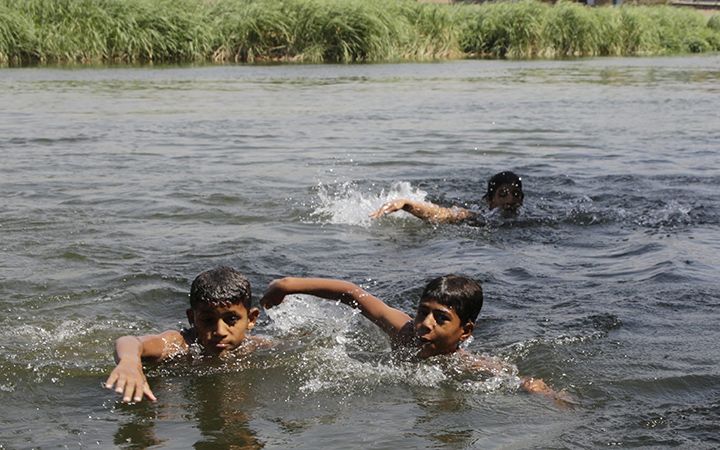 Egyptian children swim in the Nile river in Cairo, Egypt, Thursday, Aug. 13, 2015. A blistering heat wave has smothered large swaths of Egypt in recent weeks.