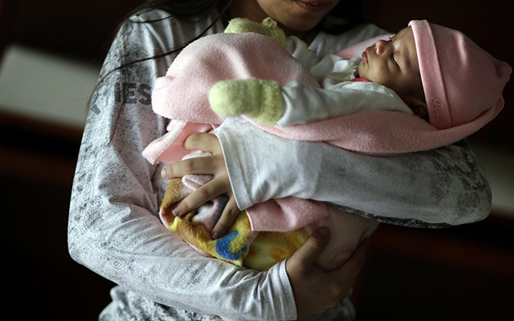 A 13-year-old girl holds her one-month-old baby at a shelter for troubled children in Ciudad del Este, Paraguay. The girl said she was raped by her stepfather from the time she was 10 and became pregnant when she was 12. Another pregnant girl, age 11, whose case drew international scorn when Paraguay's government denied her an abortion, gave birth on Thursday, Aug. 13, 2015.