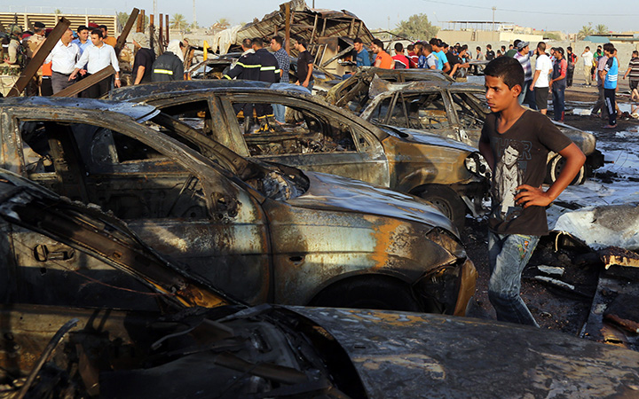 Civilians gather at the scene of a deadly car bomb in the Habibiya neighborhood of Sadr City, Baghdad, Iraq, Saturday, Aug. 15, 2015.