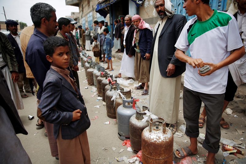 Yemeni people stand in a line to buy canisters of gas, after waiting for hours at a street in Sanaa, Yemen, Tuesday, Aug. 18, 2015. The Saudi-imposed blockade has created severe shortages of gas, petrol, and other goods, causing prices to skyrocket.
